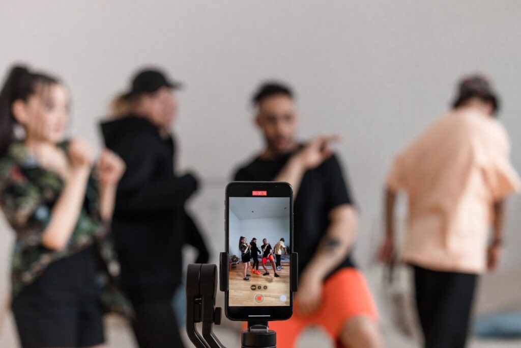 Smartphone recording a group performance from its own angle, illustrating how each participant’s channel can create a different video, archive, and viewing record.